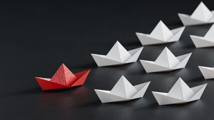 Different business concept.new ideas. paper art style. creative idea.Leadership concept with red paper ship leading among white.3D rendering on black background.