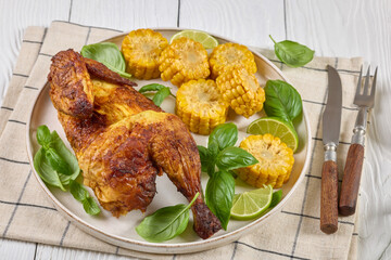 half of bbq chicken with corn cobs coins and basil
