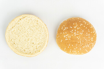 Hamburger bun with sesame seeds isolated on white background.