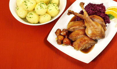 Roasted Christmas Goose on a Plate and red Placemat with Christmas Decoration