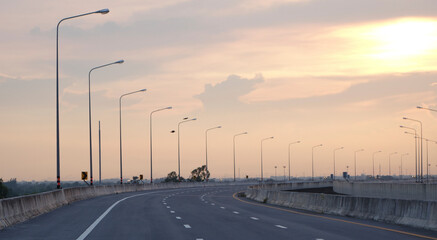 Panoramic city skyline and mountain with empty asphalt road at sunset