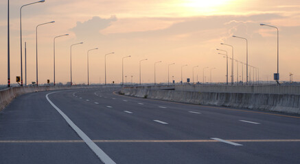 Panoramic city skyline and mountain with empty asphalt road at sunset