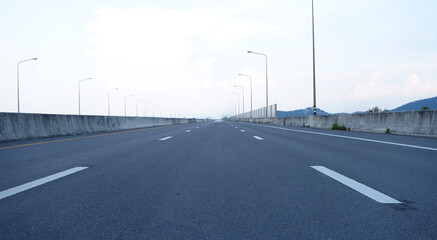 Panoramic city skyline and mountain with empty asphalt road at sunset