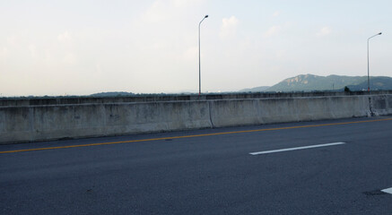 Panoramic city skyline and mountain with empty asphalt road at sunset