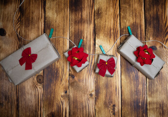 Christmas green clothespin with crafted presents with red bows on a wood background 