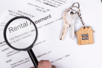 Rental or Residential Lease agreement contract, magnifying glass, and house keys. Short and long...