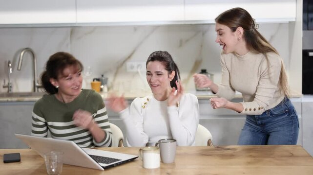 Women are sitting at computer and are immensely happy, exclaim joyfully and are fortunate to receive good news about win