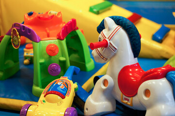 Fototapeta premium Swing horse and other branded toys in a play room