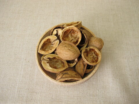 Craft material made from halved walnut shells in a wooden bowl
