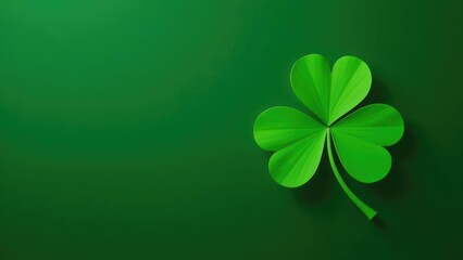 A single, vibrant green shamrock leaf sits on a dark green background. Concept of a St. Patrick's Day symbol.