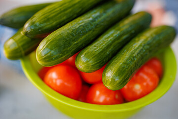 Vibrant Harvest: A Bounty of Fresh Cucumbers and Juicy Tomatoes Dancing Together in a Rustic Bowl.
