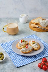 Cold appetizer, mackerel rillettes on white bread toasts on ceramic plate on gray concrete background. Recipes fish, seafood.
