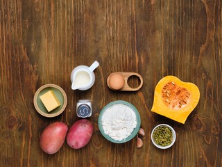 Prepared ingredients for pumpkin gnocchi or dumplings on brown wooden background. Recipes pumpkin.