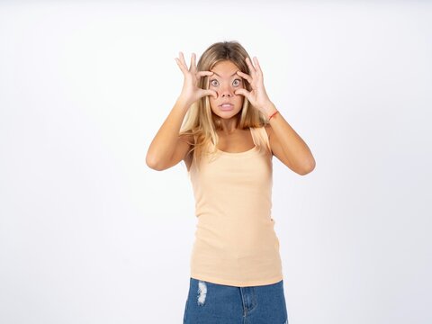 Beautiful teen girl wearing sleeveless t-shirt keeping eyes opened to find a success opportunity.