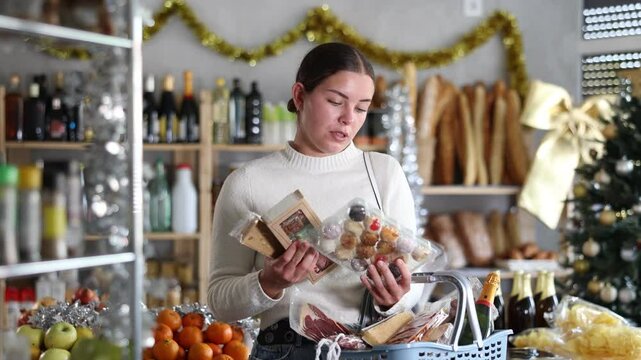 Female shopper selects sweet nougat and panellets in grocery section of a supermarket for gifting and celebrating Christmas. High quality 4k footage