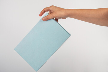 Blank book cover in hand on white background.
