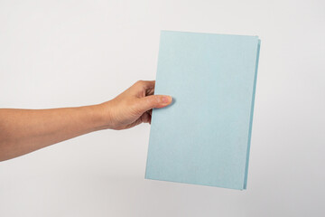 Blank book cover in hand on white background.