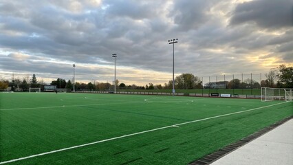 Green artificial turf field on a cloudy day, athletic field, landscape, artificial grass
