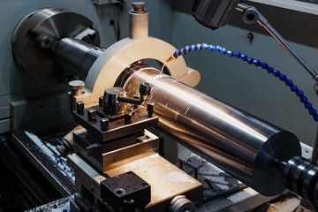 Precision in Motion: A Metalworker's Lathe Shapes Metal into Perfect Cylinders, Capturing the Art of Craftsmanship in Every Turn.