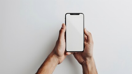 A man’s hand holds a smartphone. A phone is carried by a man in a white scene. A man’s hand and a clean design.
