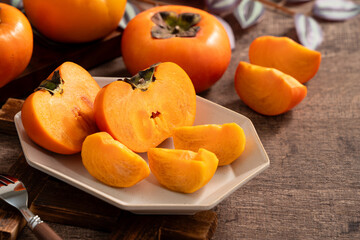 Fresh ripe persimmon fruit on wooden table background.