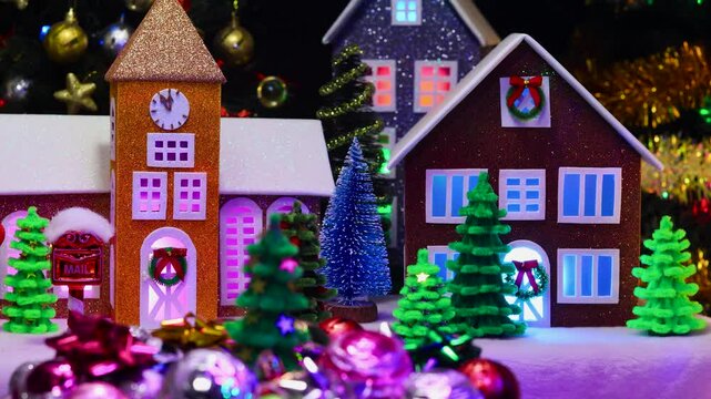 A Christmas tree surrounded by various decorations rotates against the backdrop of a Christmas town with colorful trees and a chapel
