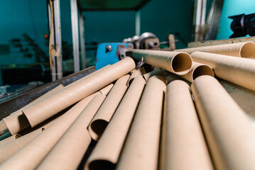 Machine for cutting cardboard bushing for printing house. Cutting cardboard core and spools for winding paper and film. Equipment for production. Selective focus