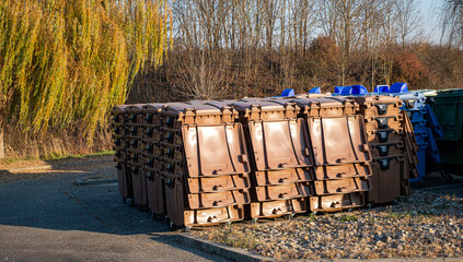 rows of new municipal colored trash cans with wheels
