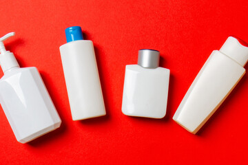 Set of White Cosmetic containers isolated on colored background, top view with copy space. Group of plastic bodycare bottle containers with empty space for you design