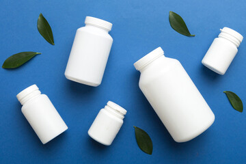 supplement pills with medicine bottle health care and medical top view. Vitamin tablets. Top view mockup bottle for pills and vitamins with green leaves, natural organic bio supplement, copy space