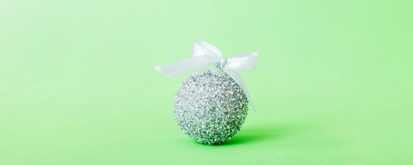 Christmas ball on colored background. decoration bauble with ribbon bow with copy space