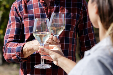 man and woman tasting white wine in vineyard