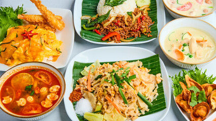 A selection of popular Thai dishes including Pad Thai, Pad Krapow, Green Curry, and Thai Style Omelette Rice. Each dish is a vibrant representation of bold flavors, herbs, and spices typical of Thai c