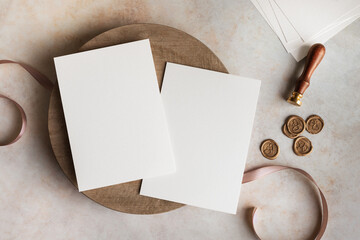 Blank wedding invitation cards mockup with wax stamps and ribbon top view on table