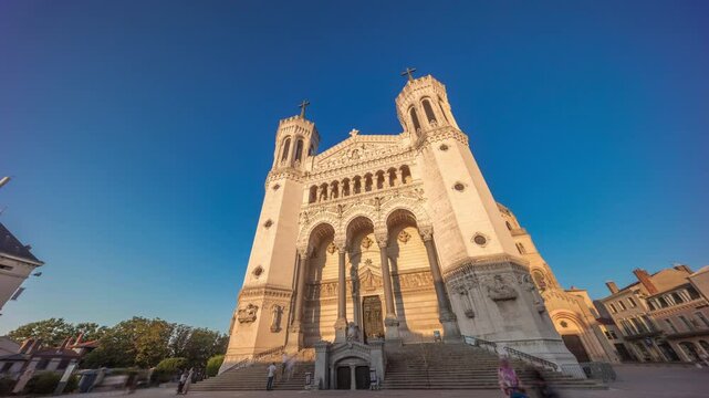 Hyperlapse front view of the Basilica of Notre Dame de Fourviere during sunset in Lyon, France. This iconic minor basilica is illuminated with warm light, overlooking the city from a hilltop timelapse