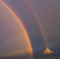 Natural colorful double rainbow in clouds.