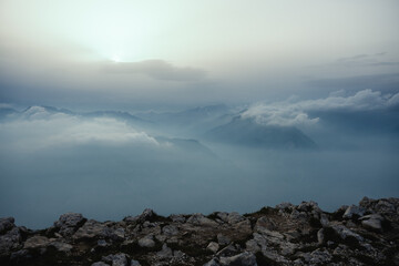 Low altitude clouds and fog on the top of the mountains during a cloudy sunset in the Northern Italy above the Lake Garda