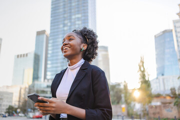 Portrait of a young woman using mobile phone in city
