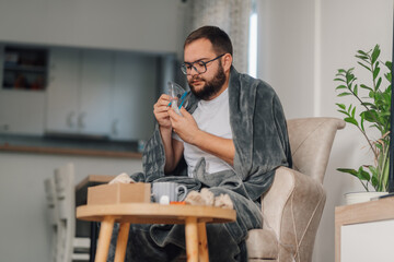 Sick man is preparing medical inhaler at home