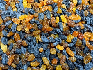 Raisins blue and golden variation dried fruits background.