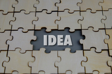 Fototapeta premium wooden puzzle with the word idea. concept idea. concept of thinking. Creativity, New idea, analytical thinking, inspiration concept, vision concept.