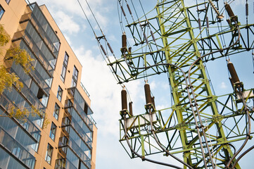 power transmission tower and residential building view from below