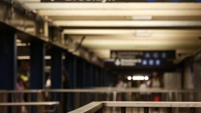 New York City, Manhattan. Defocused subway station interior, underground metropolitan transfer. Public metro transport. Railway change hub, passenger traffic junction. People in NYC, United States.