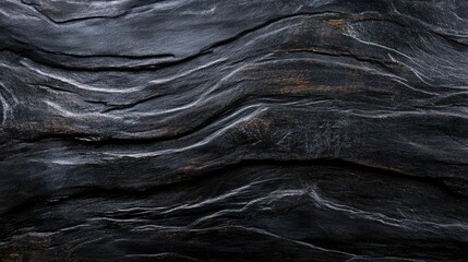 Textured black and grey rustic wooden surface showcasing wavy patterns, rich grain details, and a weathered appearance, ideal for backgrounds or design elements.