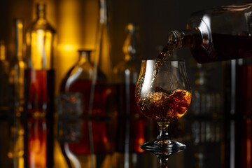 Pouring brandy from a bottle into a glass.