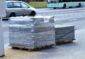 Paving slabs packed in stretch film, standing on the ground