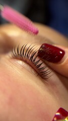 Close-up of a human eye with long eyelashes. The eye has a light iris, possibly green or blue. The...