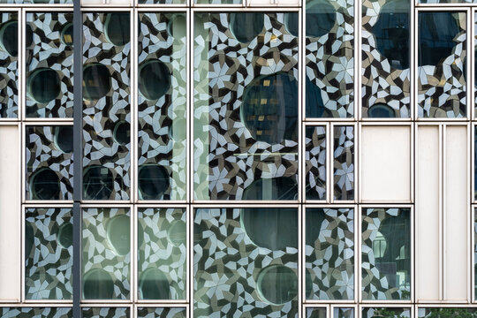 This photograph exhibits a building fa&ccedil;ade adorned with geometric elements, including circular and floral motifs, creating a complex and visually captivating pattern.