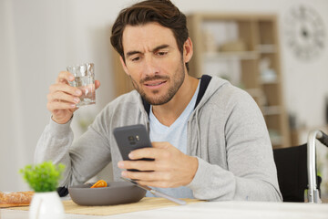 casual man looks at the smart phone while having lunch