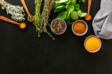 Frame of green herbs and spices in bowls for cooking, top view